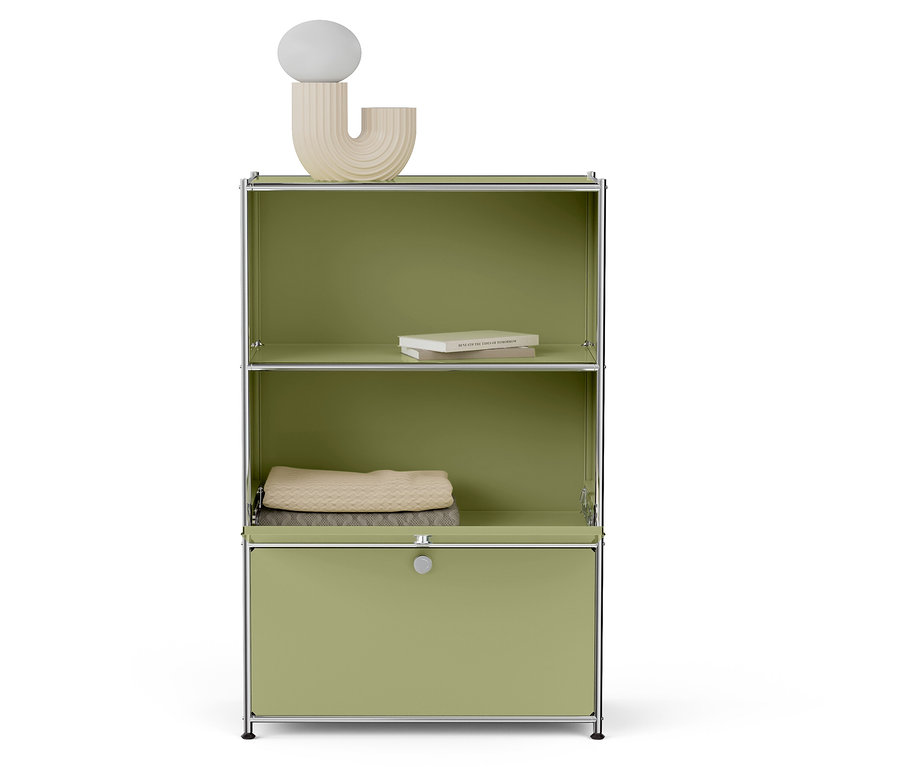 Zelený regál s knihami, dekou a lampou.