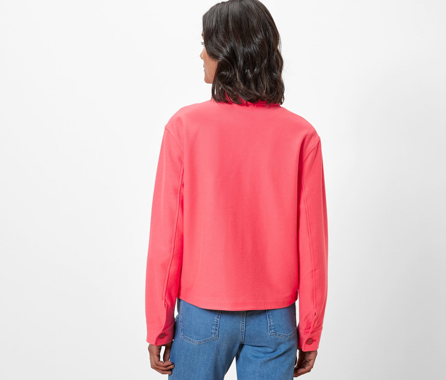 Zezadu je vidět žena v džínové bundě.
