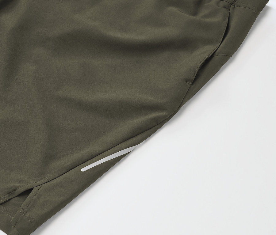 Detail khaki sportovních šortek s kapsou a reflexním pruhem.