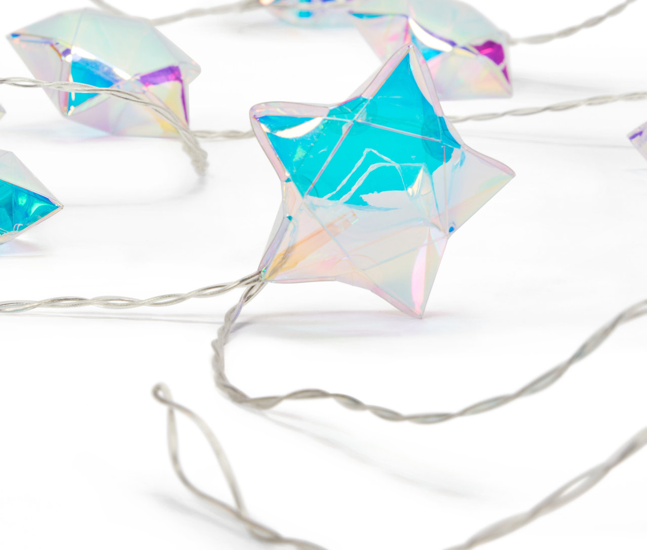 Detailní záběr na řetěz světel ve tvaru hvězdy s duhovým povrchem na bílém pozadí.