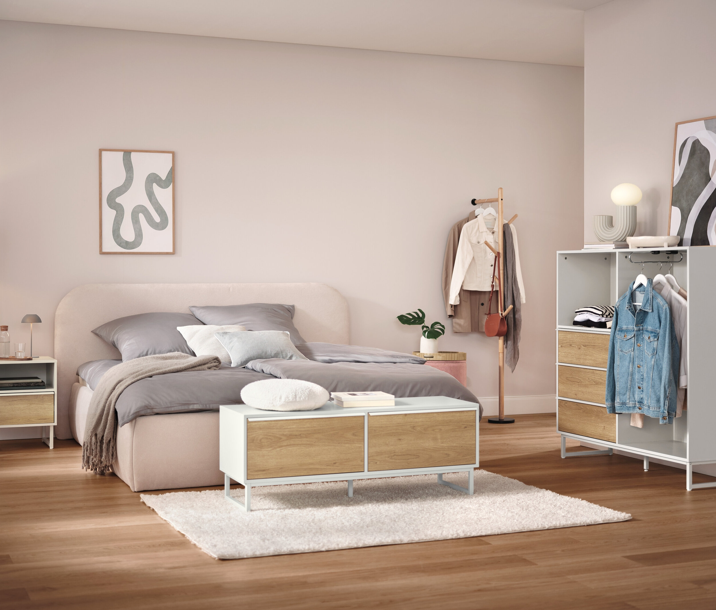 Ložnice s postelí, nočním stolkem, skříní a věšákem na oblečení.