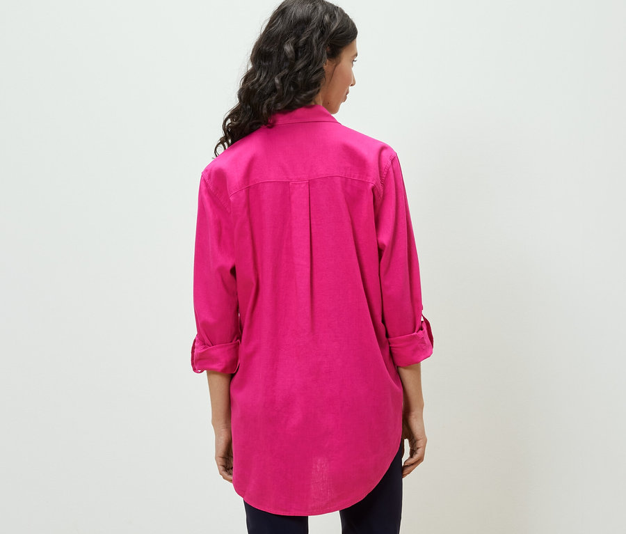 Žena má na sobě dlouhou lněnou halenku, růžovou.