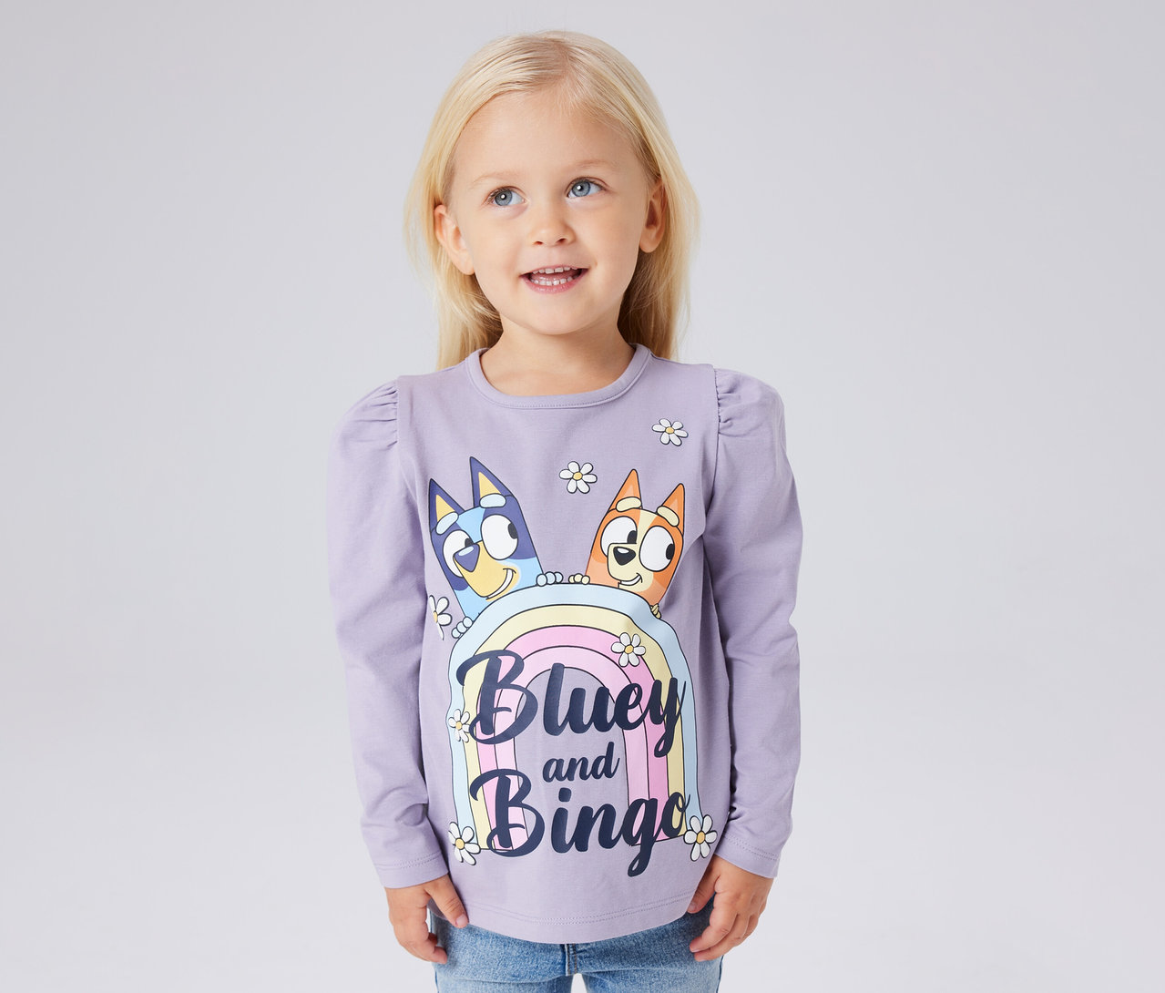 Dívka má na sobě fialové dětské triko s dlouhým rukávem NAME IT »BLUEY« s potiskem Bluey a Bingo.