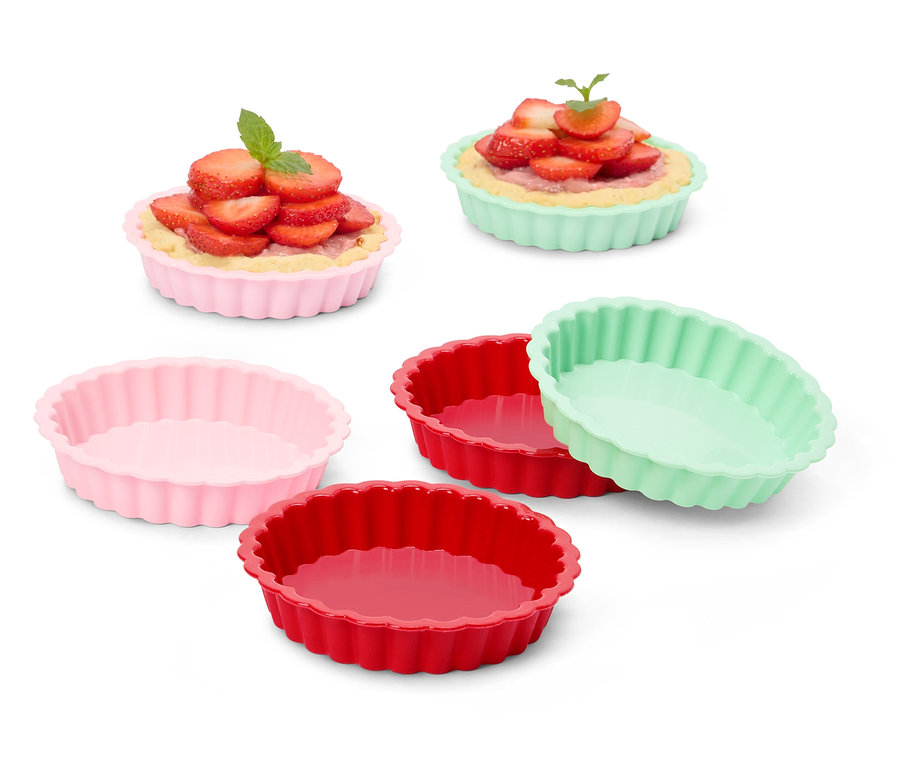 Několik barevných formiček na tartaletky, některé plněné jahodovými tartaletkami.