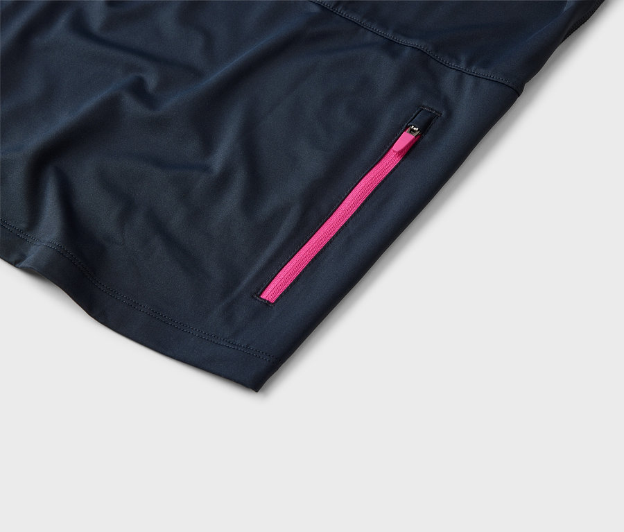 Detailní záběr tmavě modré látky s růžovým zipem.