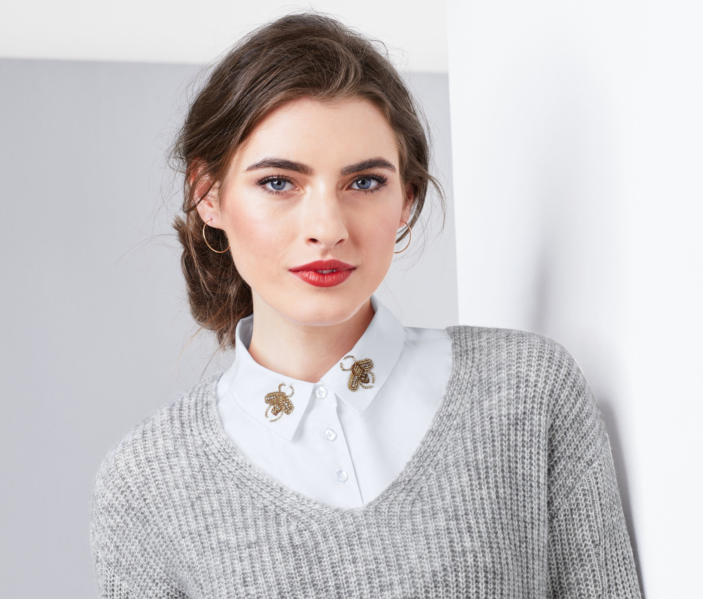 Žena nosí falešný límec s výšivkou včel.