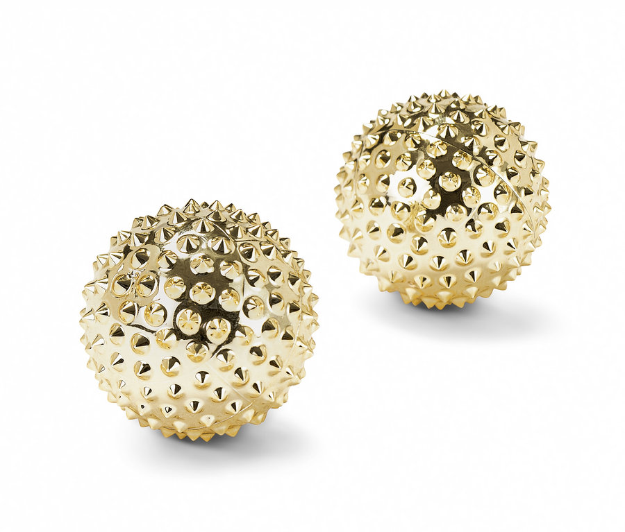 Dva zlaté kuličky na prstovou gymnastiku na bílém pozadí.