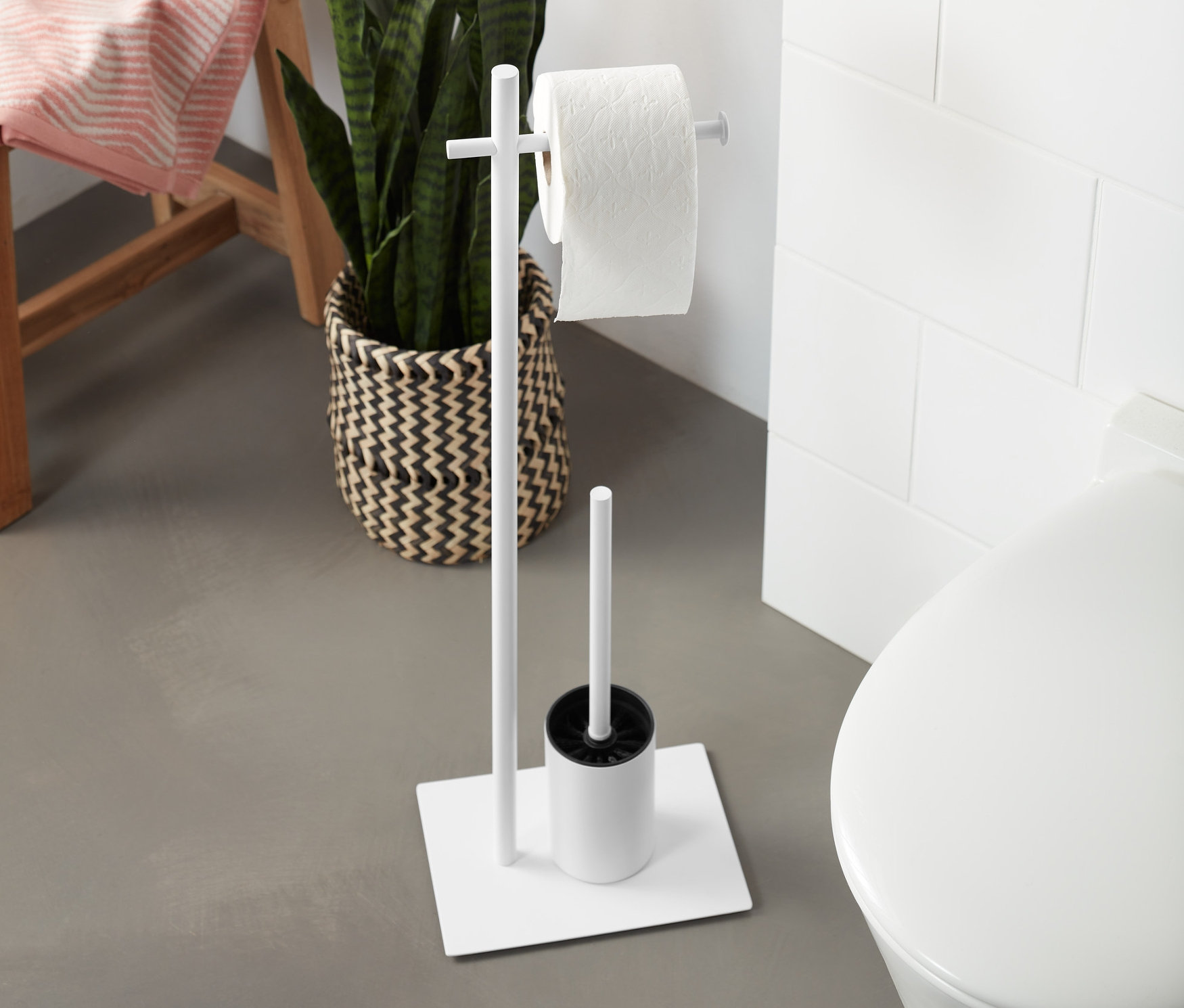 Stojan na WC štětku a toaletní papír vedle záchodu.