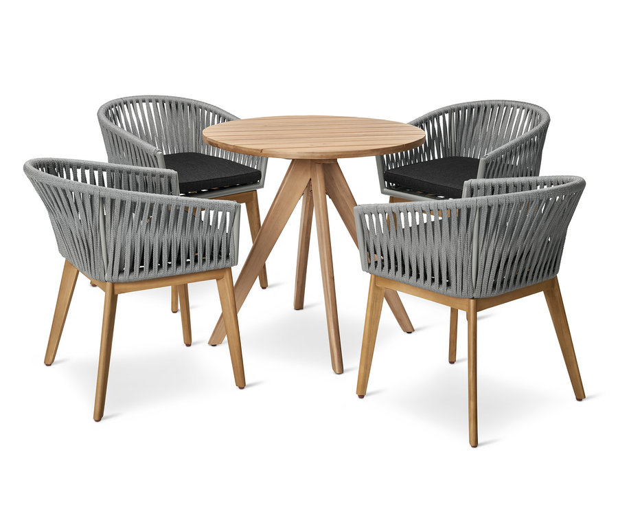 Čtyři jídelní křesla s textilním výpletem obklopují kulatý zahradní stůl.
