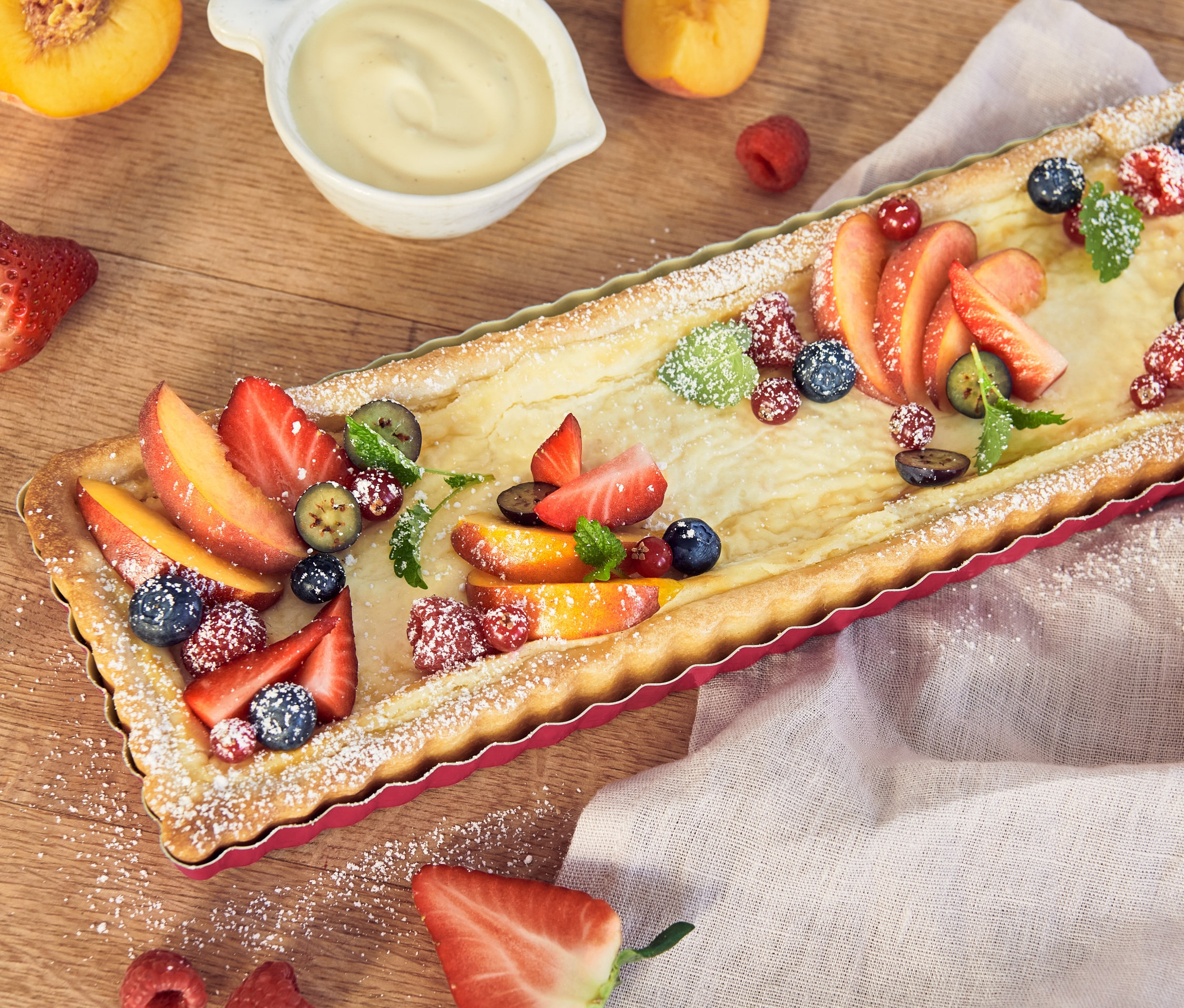 Ovocný koláč ve formě na tarte s broskvemi, jahodami, malinami a borůvkami.