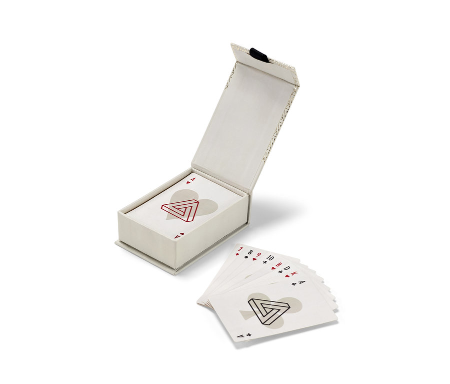 Otevřená sada hracích karet Skat v krabičce a rozložené karty vedle.