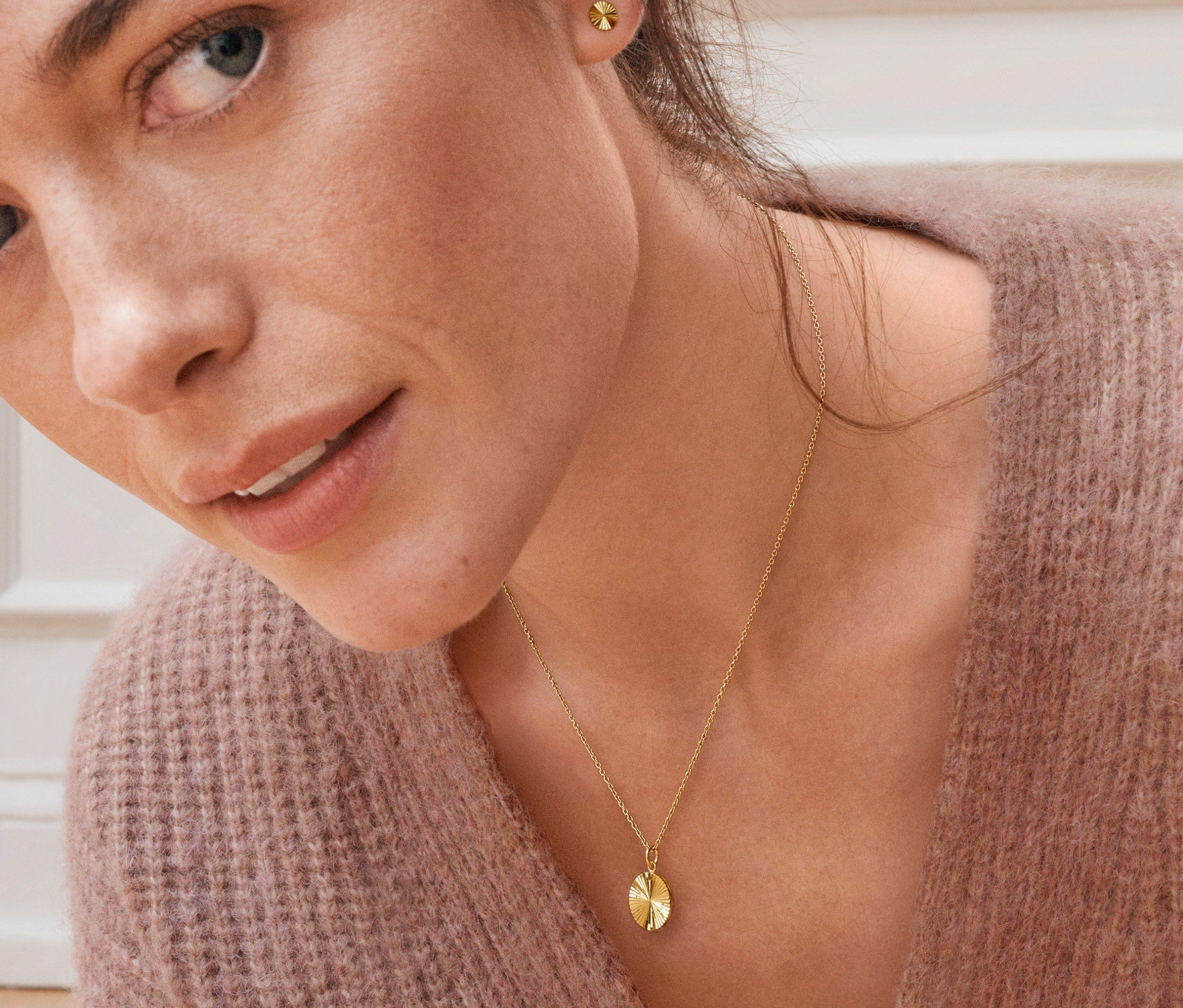 Portrét ženy s náušnicemi a náhrdelníkem z pozlaceného stříbra 925/1000 ve tvaru slunce.