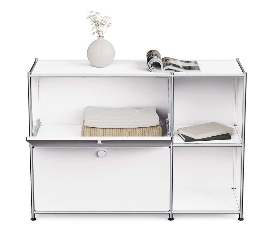 Bílá kovová odkládací skříňka »CN3« se 2 výklopnými dvířky, na které je váza s květinami a časopis.