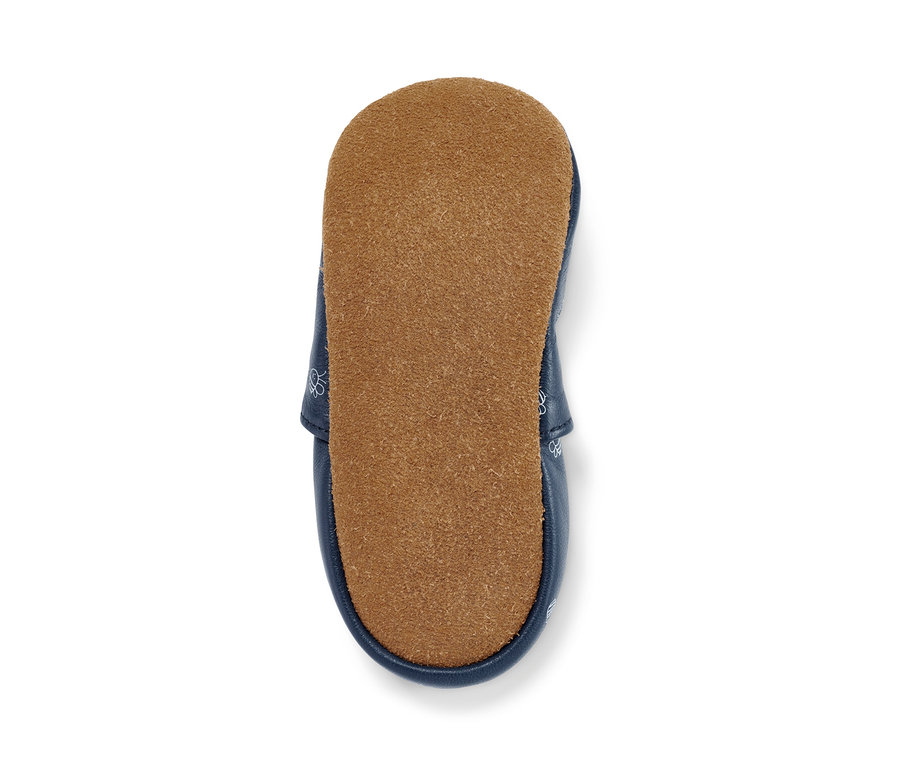 Detail dětské kožené botičky s hnědou podrážkou.