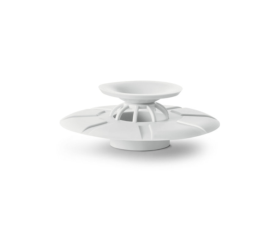 Bílé odtokové sítko a zátka na bílém pozadí.