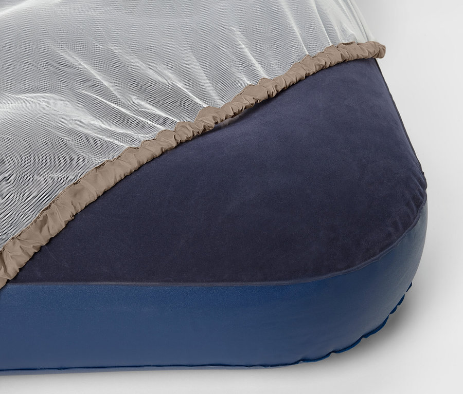 Cestovní moskytiéra leží na matraci.