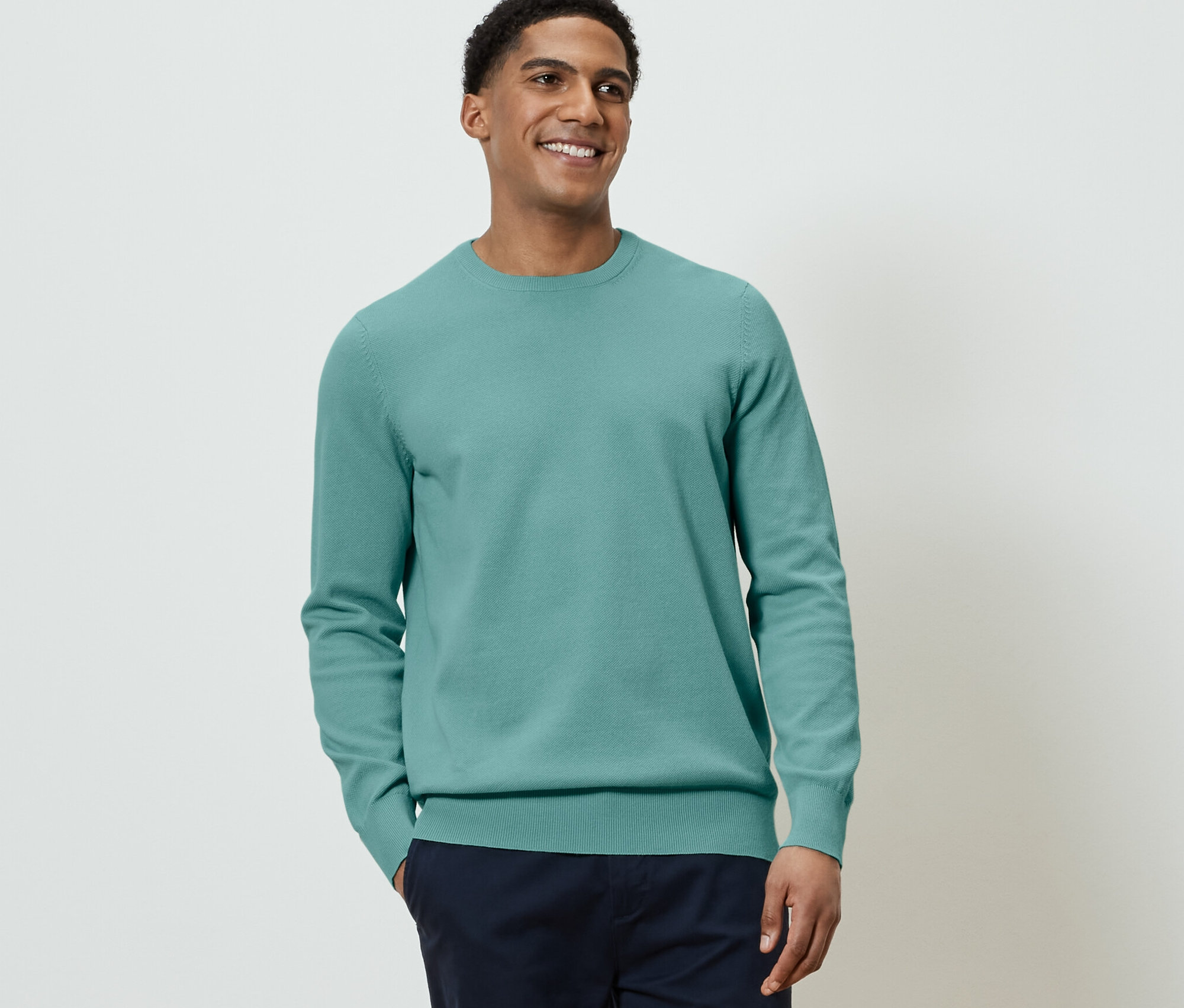 Muž má na sobě pletený svetr.