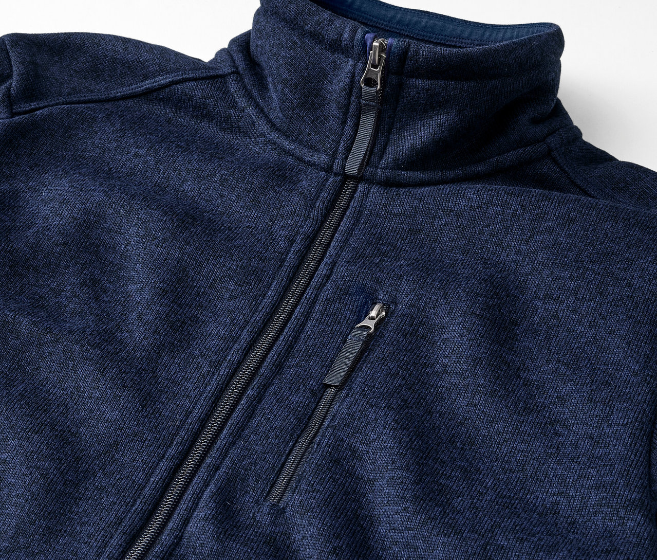 Detail modré bundy z pleteného fleecu se zipem.