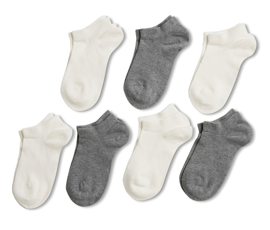 Sedm párů dětských krátkých ponožek v bílé a šedé barvě.