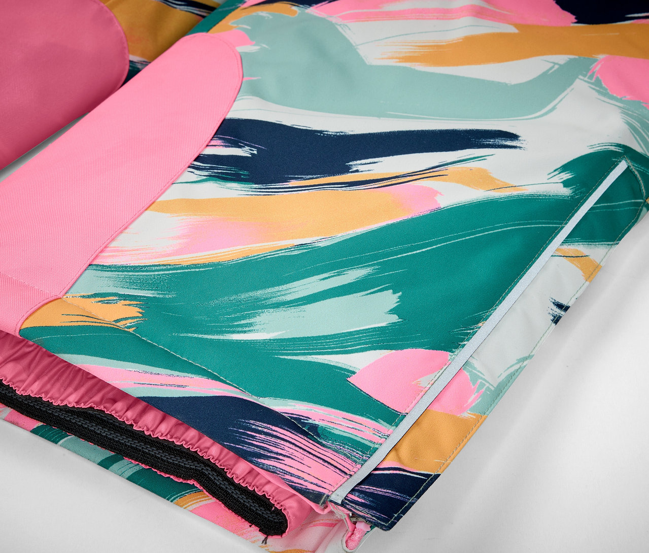 Detail bundy s barevnými tahy štětce v odstínech zelené, modré, růžové a žluté.