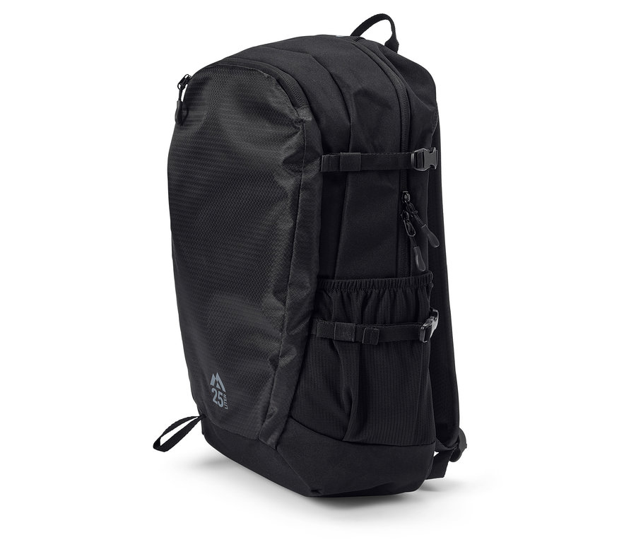 Černý batoh stojí na bílém povrchu.