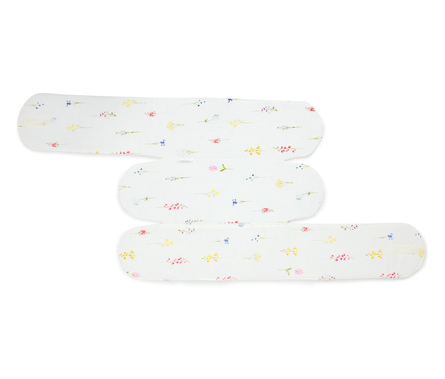 Tři bílé látkové vložky s květinovým vzorem leží na sobě.