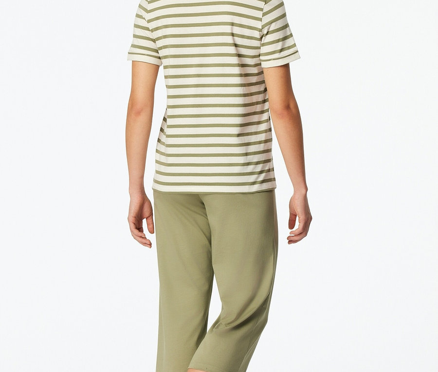 Žena zezadu v pruhovaném topu a zelených kalhotách.