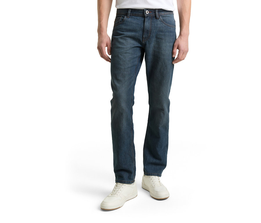 Muž má na sobě džíny Tom Tailor TT MARVIN STRAIGHT se strečovým materiálem, Mid Stone Blue Grey Denim a bílé boty.