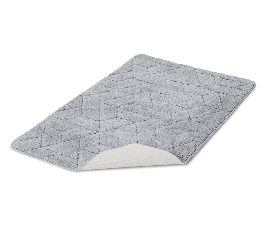 Šedý koupelnový koberec s geometrickým vzorem leží na bílém pozadí.