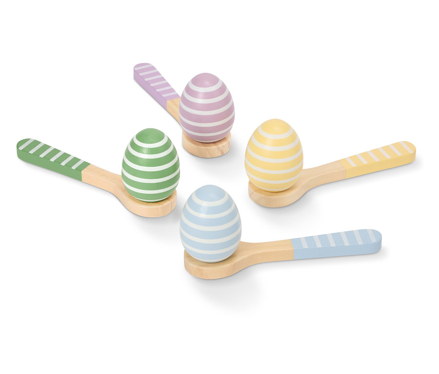 Čtyři malovaná, pruhovaná velikonoční vajíčka v pastelových barvách leží na malých dřevěných lžičkách.