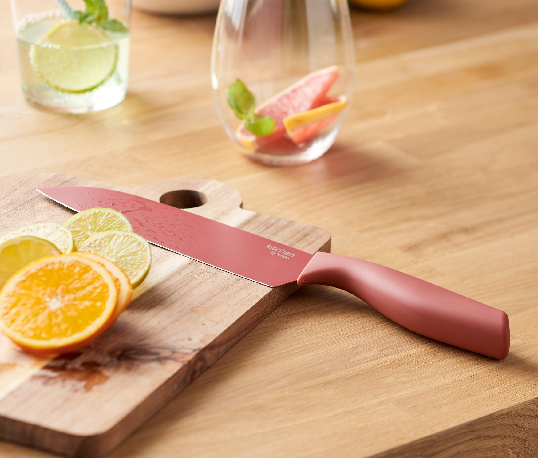 Univerzální nůž leží na prkénku s nakrájenými citrusy.