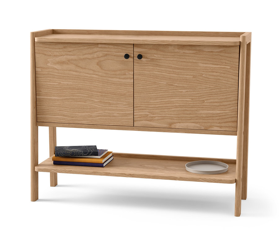 Dřevěný příborník se dvěma dvířky a policí. Na polici leží knihy a talíř.