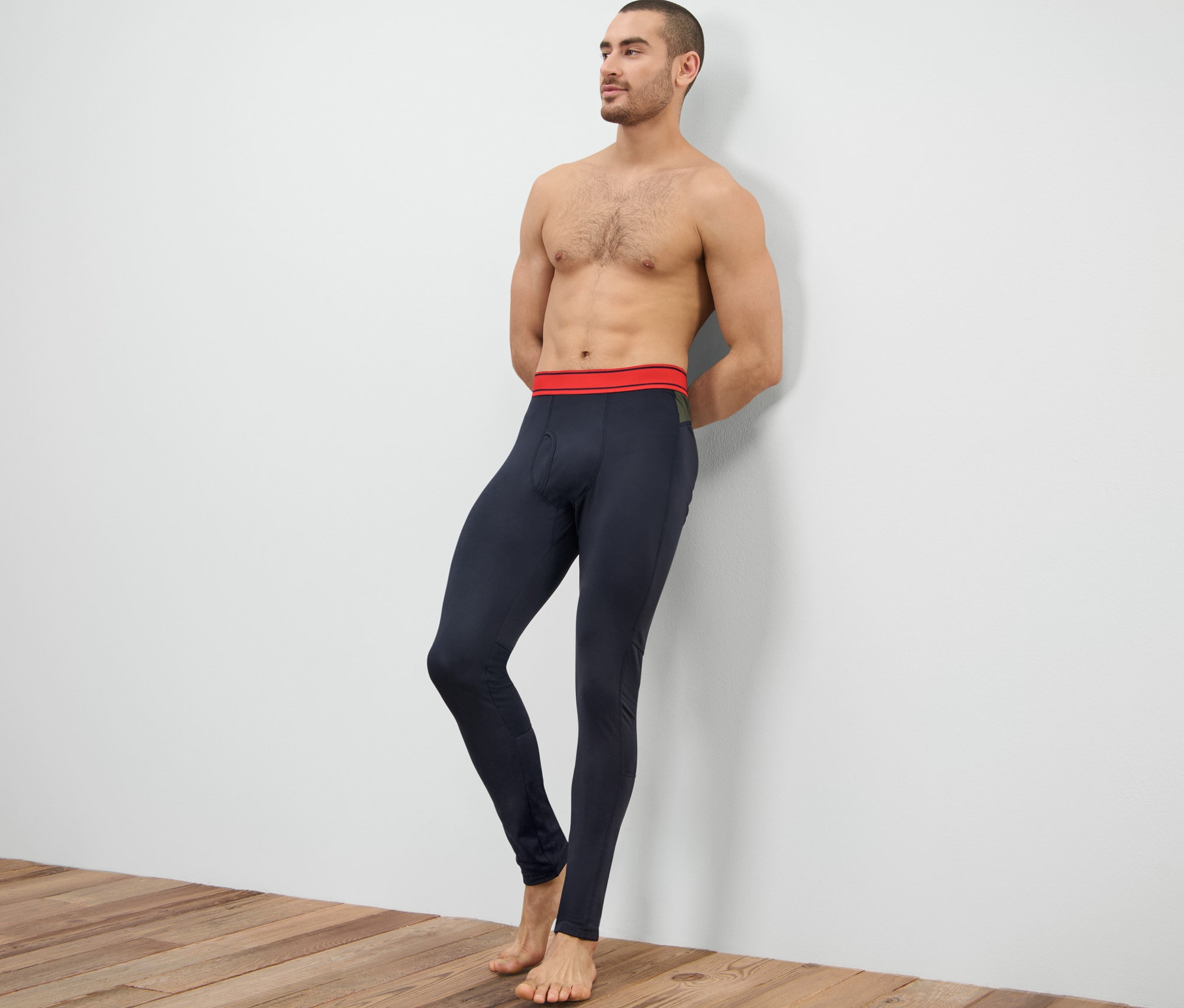 Muž opřený o zeď má na sobě funkční termospodky.