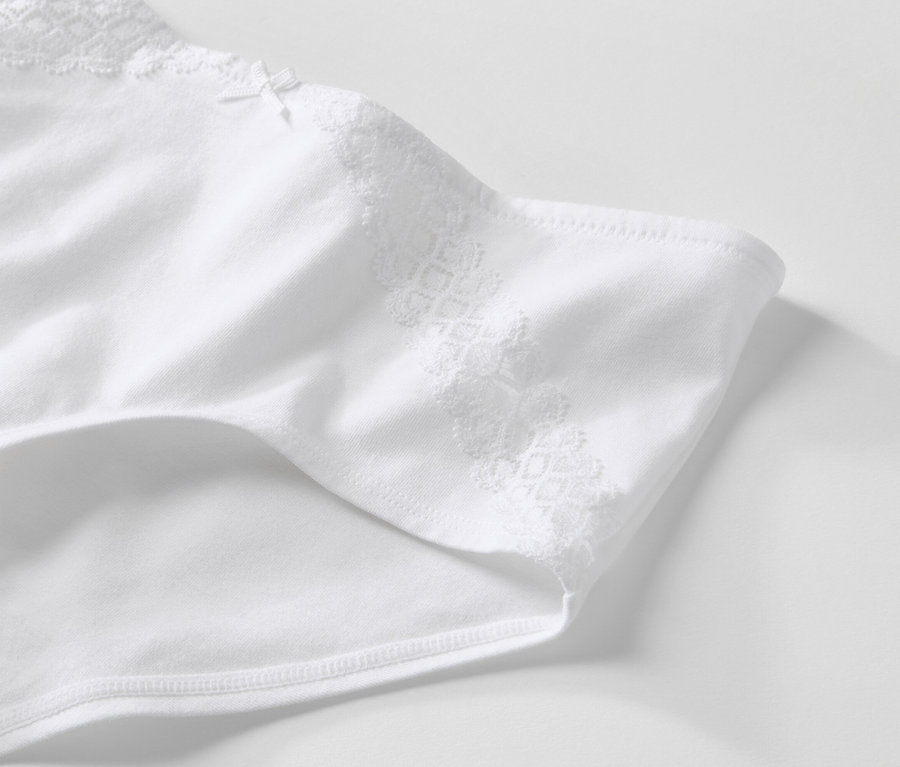 Detail bílých kalhotek s krajkou.