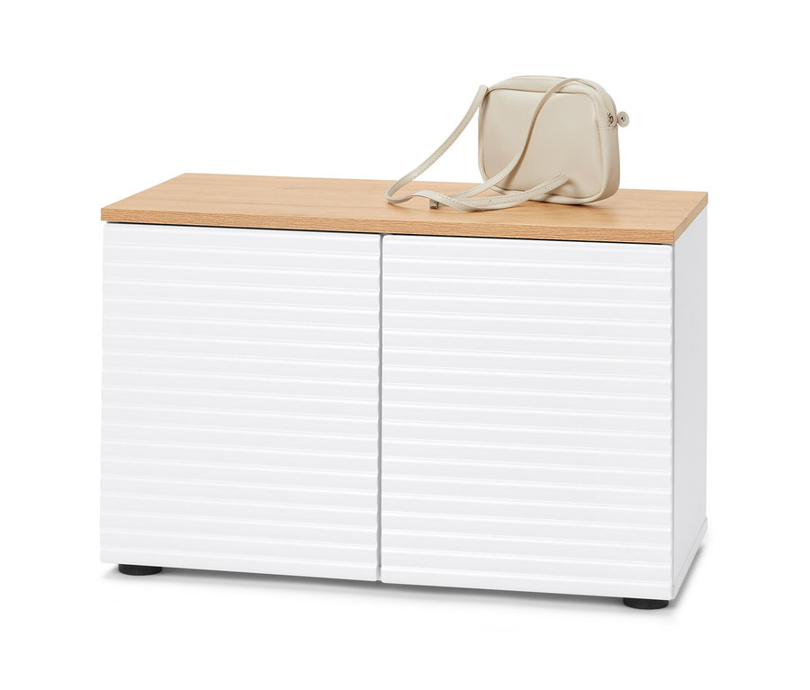 Úložná lavice s bílými dveřmi a dřevěnou horní deskou. Na horní desce leží krémová kabelka.