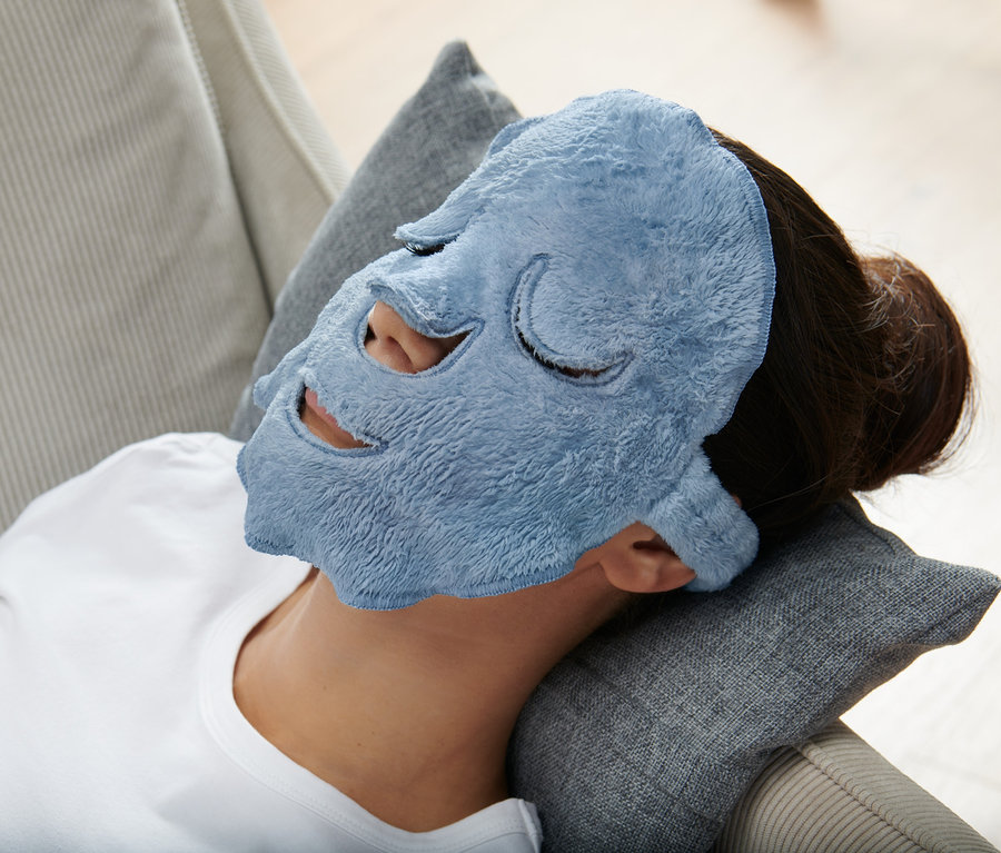 Žena leží na polštáři s modrou textilní maskou na obličej, 2 ks.