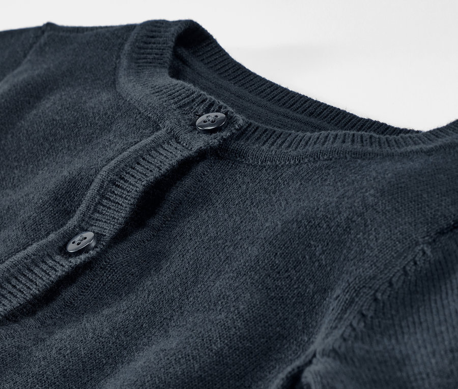 Detailní pohled na dětský pletený svetr s knoflíky.