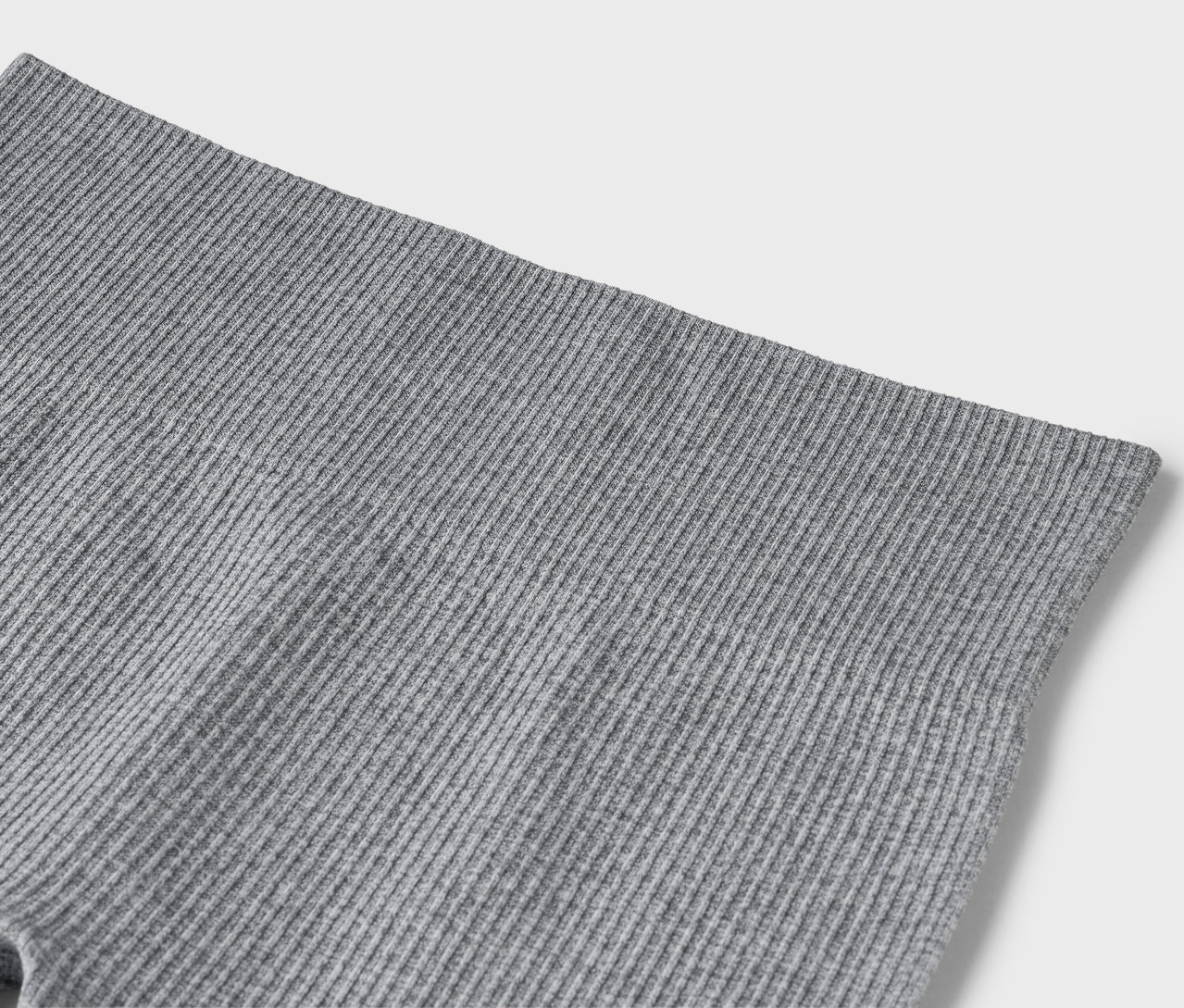 Detailní záběr šedých žebrovaných legín.
