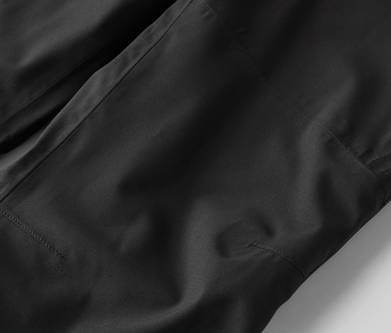 Detailní záběr na černé kalhoty.