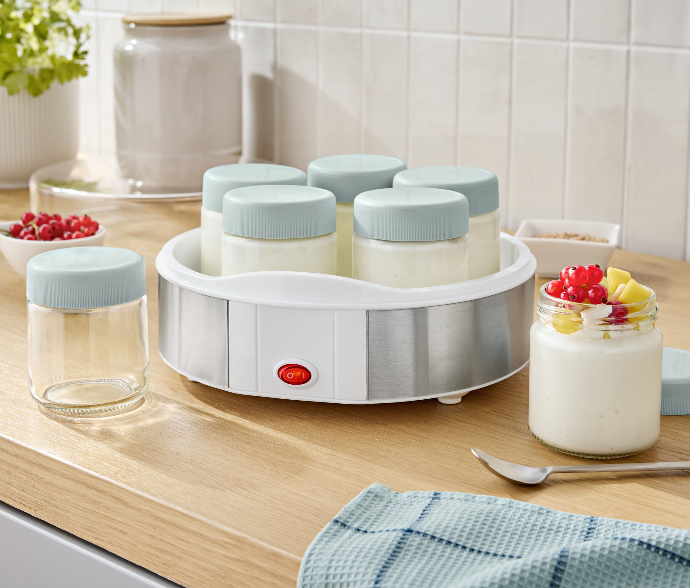 Yogurtovač se šesti sklenicemi a jednou sklenicí s jogurtem a ovocem.