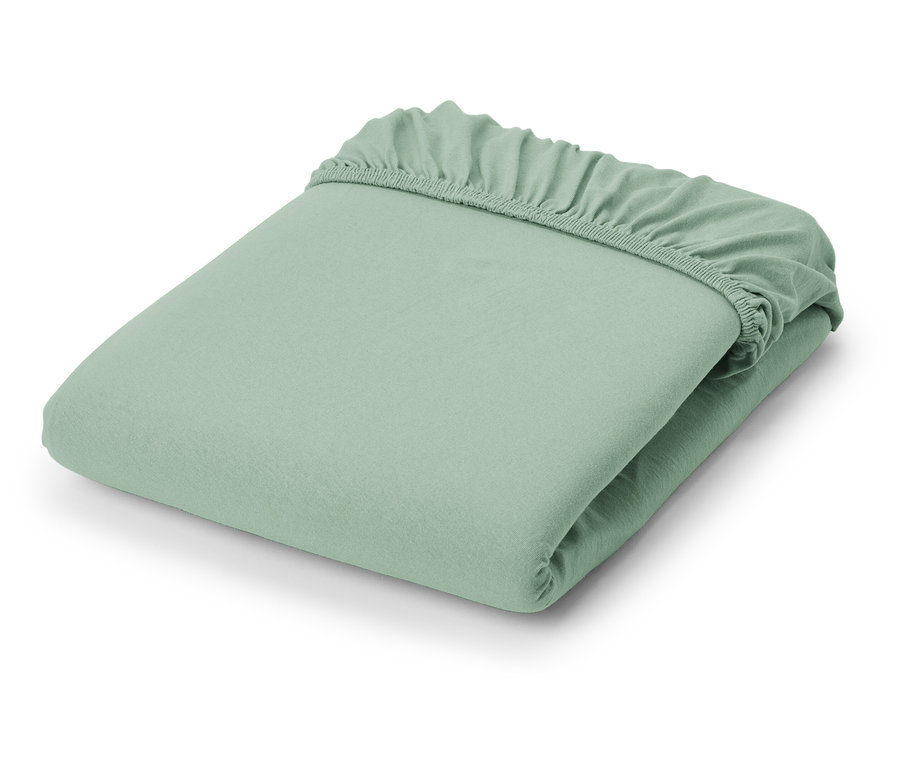 Složené světle zelené žerzejové napínací prostěradlo.