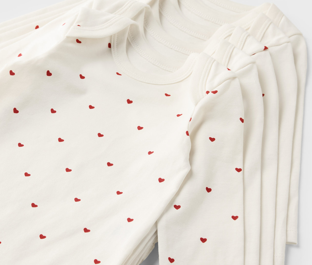 Sada pěti rostoucích body pro miminka s potiskem červených srdíček.