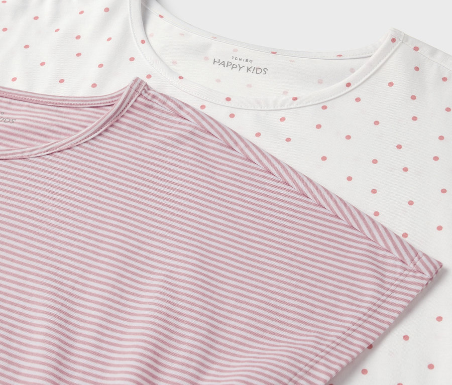 Detail dvou triček: jedno bílé s růžovými puntíky, druhé růžové s bílými proužky.
