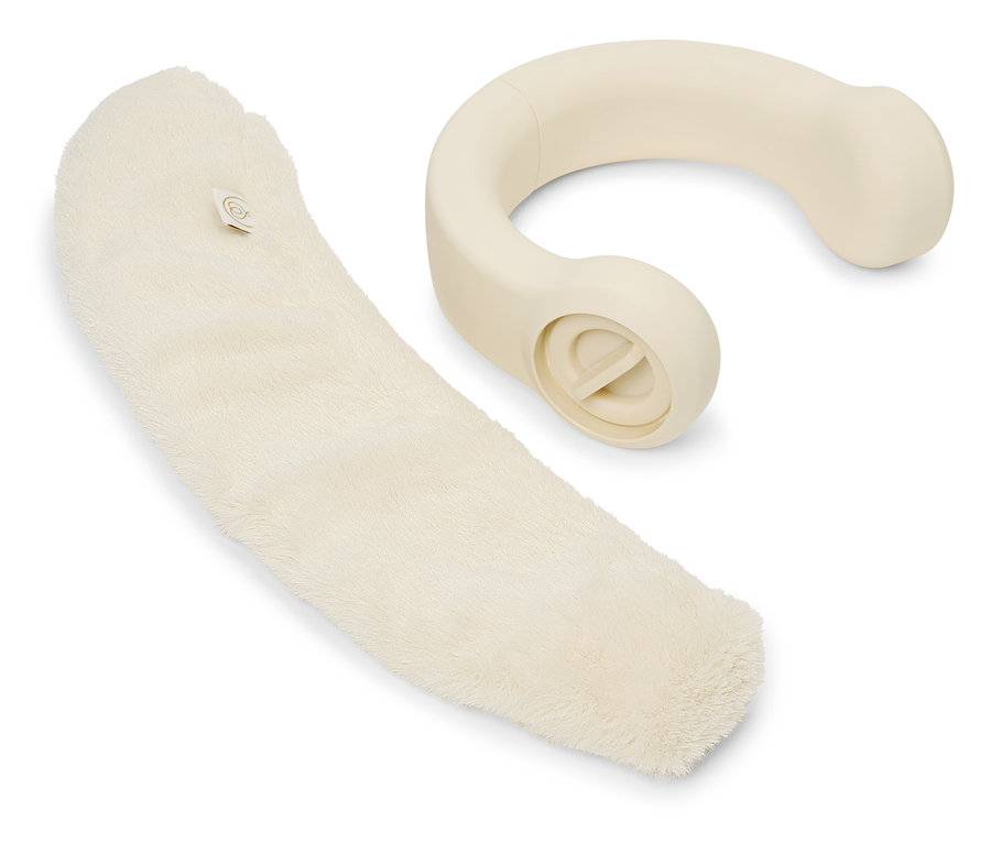 Krémový masážní přístroj leží vedle měkkého krémového návleku.