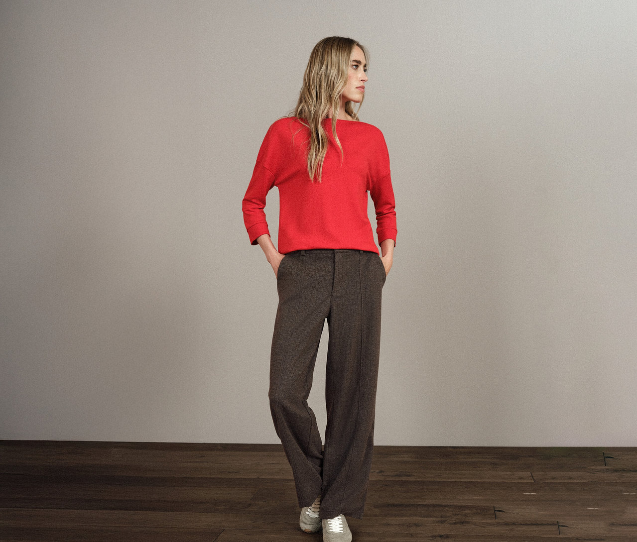 Blondýna stojí s rukama v kapsách kalhot Street One s rovnými nohavicemi.