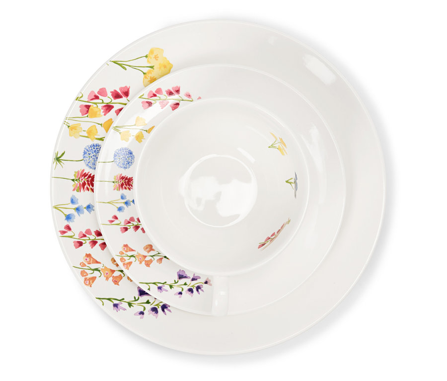 Detailní záběr na sadu bílého porcelánového nádobí s květinovým vzorem.