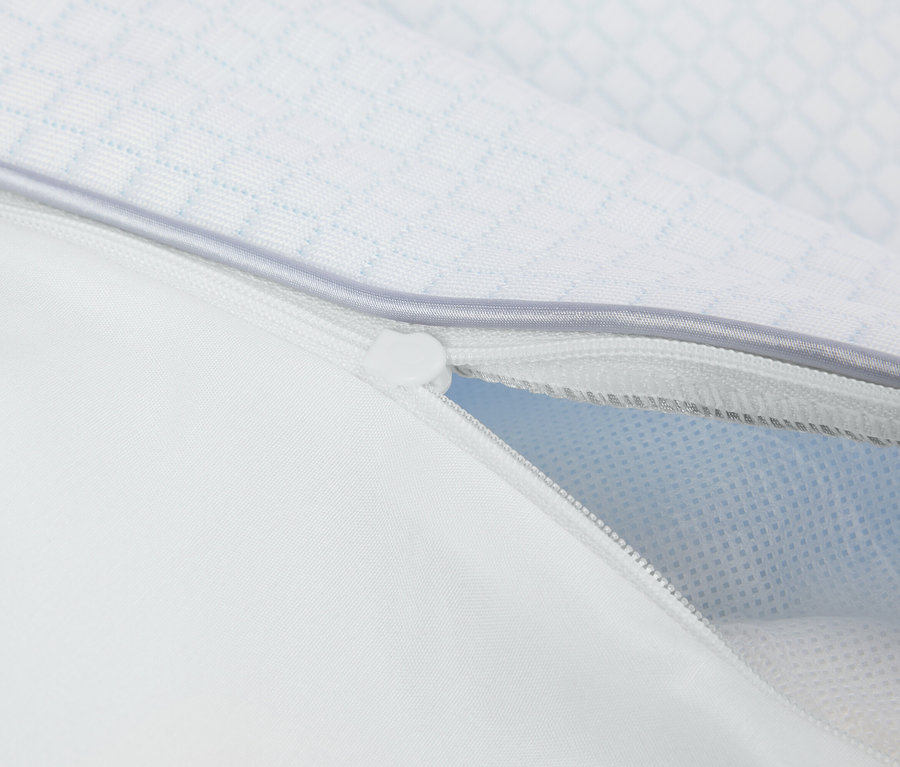 Detailní pohled na částečně otevřený, bílý zip na povlaku na polštář.
