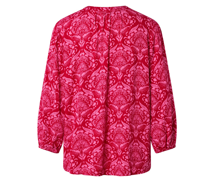 Pohled zezadu na červenou halenku s růžovým damaškovým vzorem.