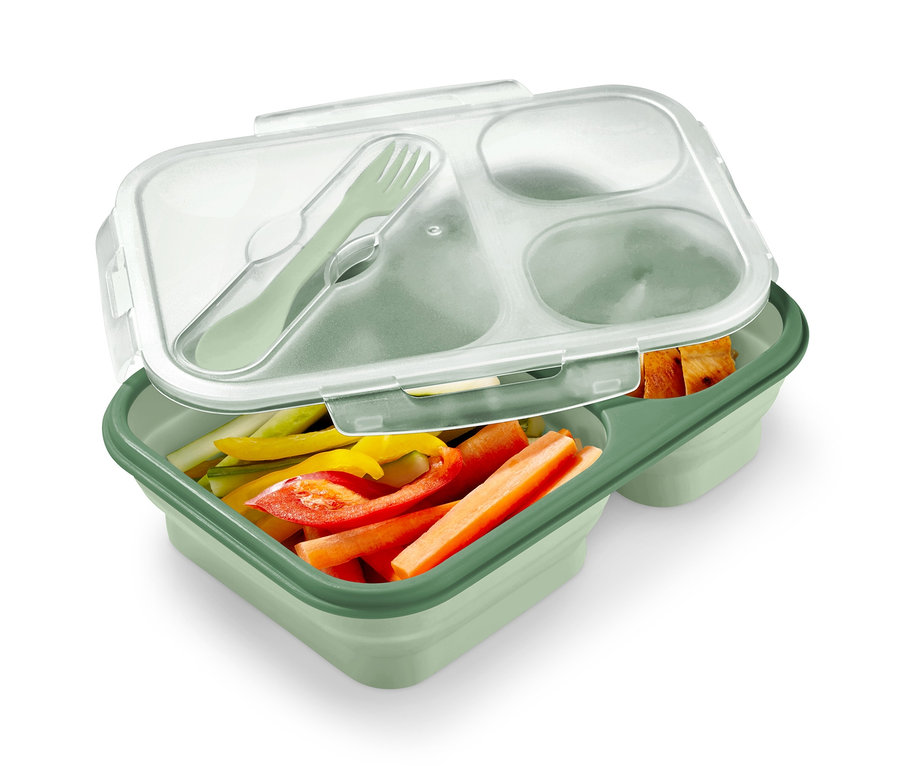 Zelená skládací dóza na oběd s nakrájenou zeleninou a příborem.