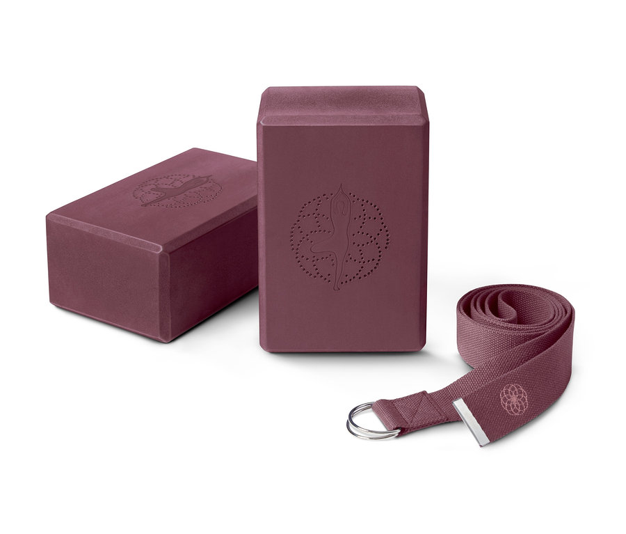 Dva fialové jógové bloky a fialový popruh na jógu ze sady na jógu.